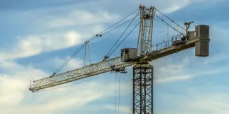 Tower crane with cloudy blue sky background