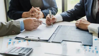 Signing a business contract. A group of business people at the meeting and sign a together business investment agreement.