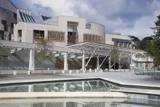 The Scottish Parliament building with reflection in water Edinburgh Scotland
