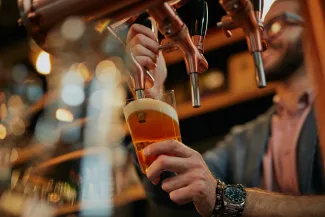 Man at bar establishment pouring beer