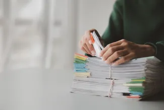 Persons hands going through stack of paperwork