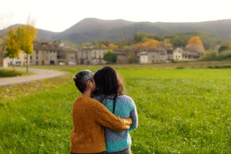 Older lesbian couple in front of housing