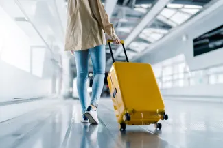 Person wheeling bag into airport for trip to France