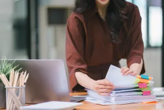 Woman with stack of tax paperwork