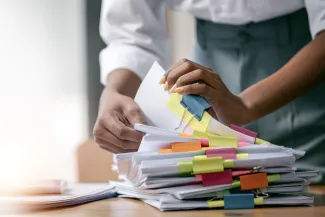 Woman with stack of paperwork