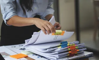 Woman with stack of paperwork