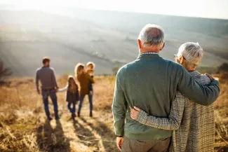 Older couple looking at their children in field