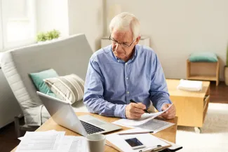 Elderly man looking through paperwork