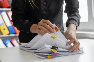 Woman with clipped stack of paperwork in hands