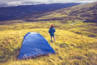 Person wild camping in Scotland