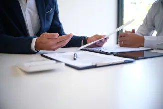 People sitting at a desk discussing documents 