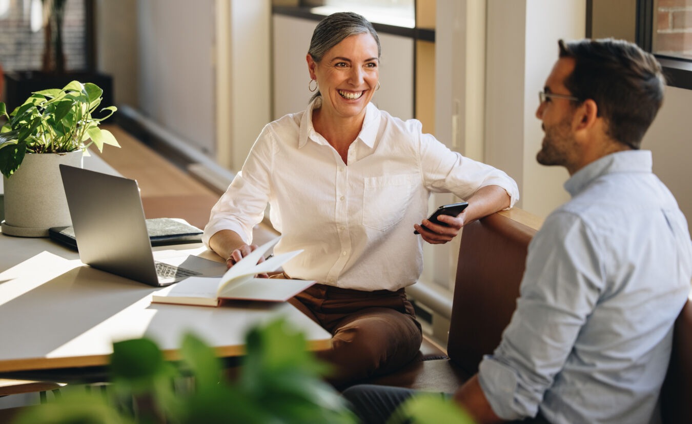 Two professionals talking at desk
