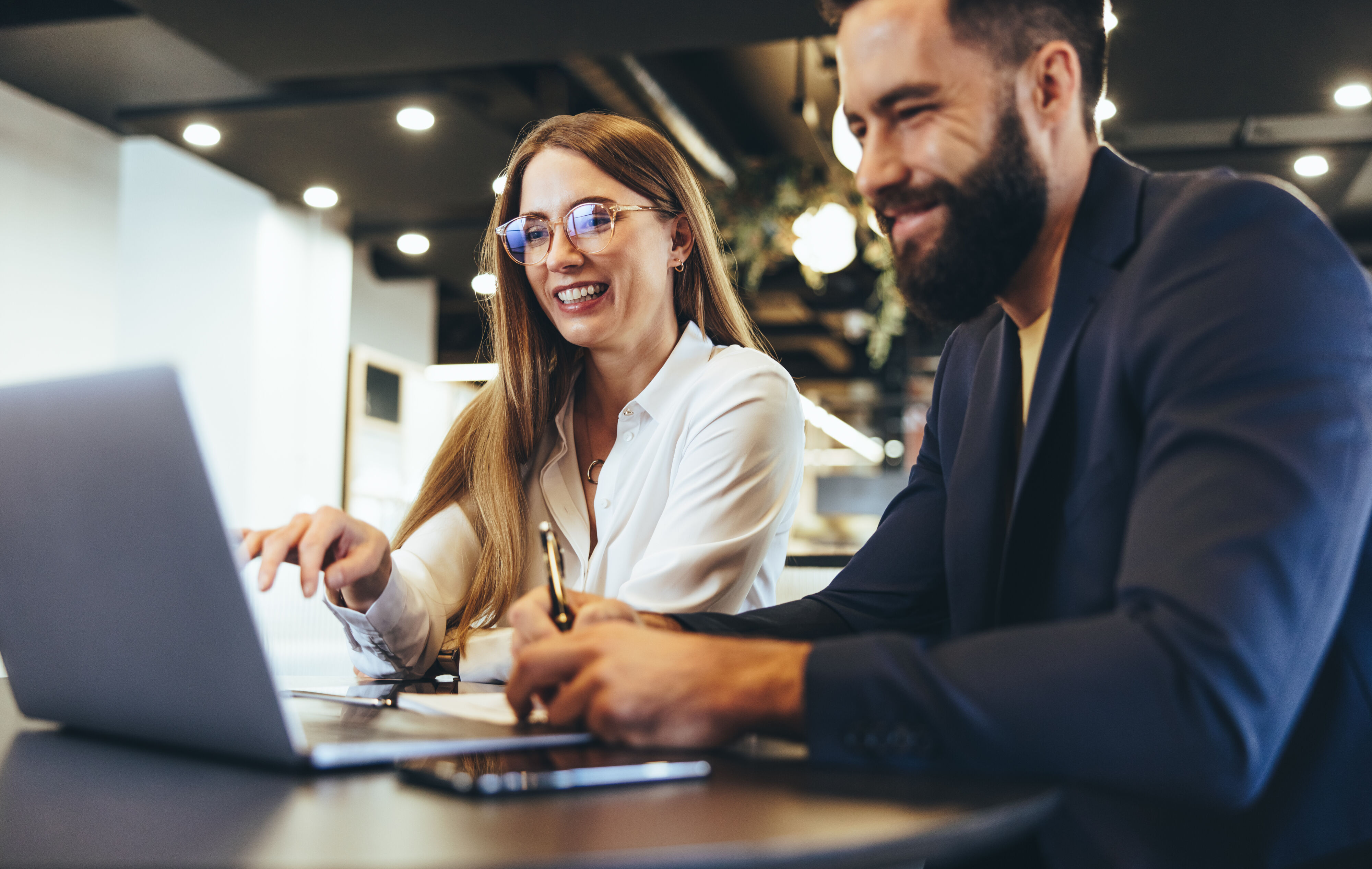 Man and woman working over laptop