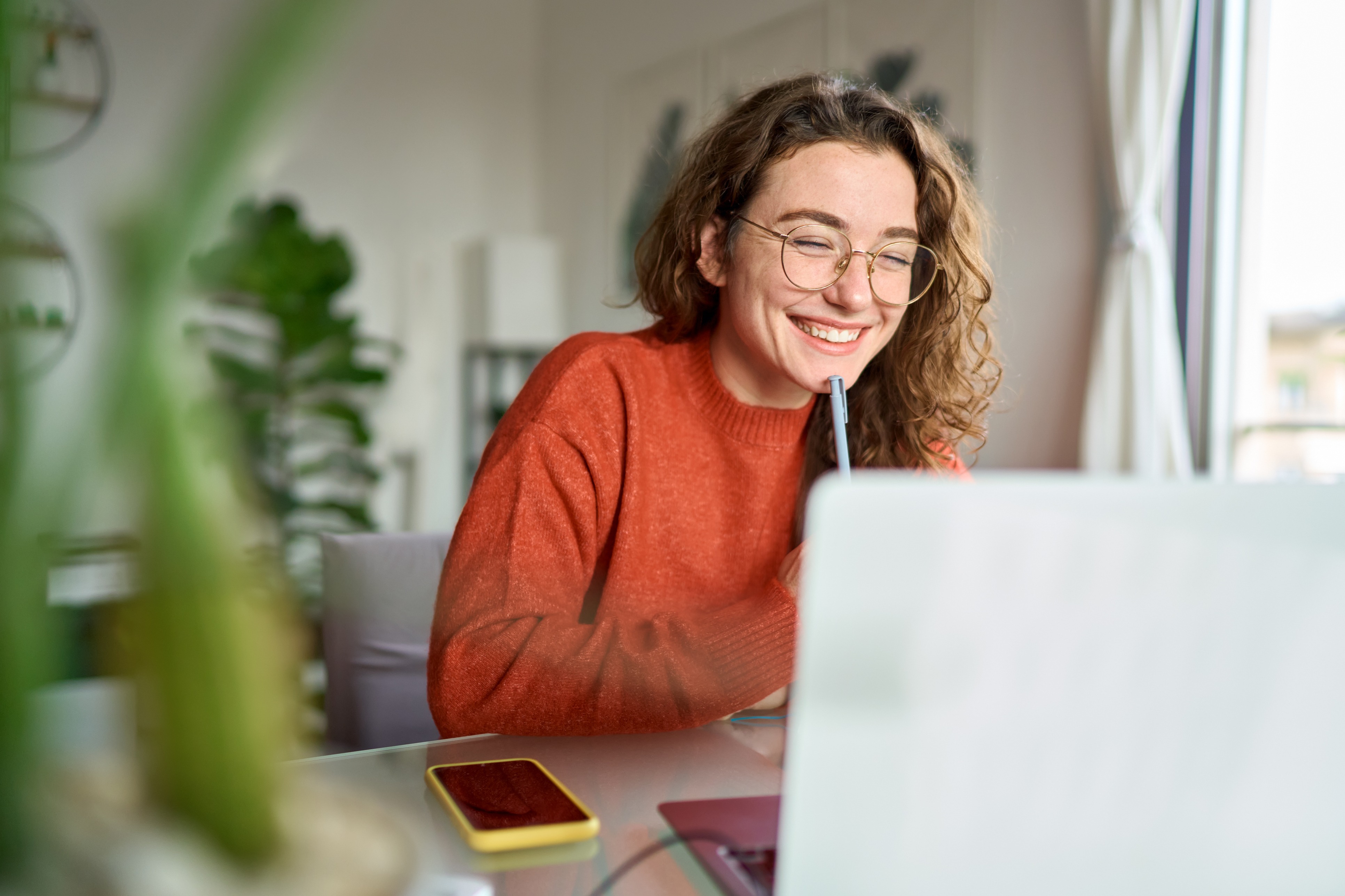 Woman laughing in front of laptop