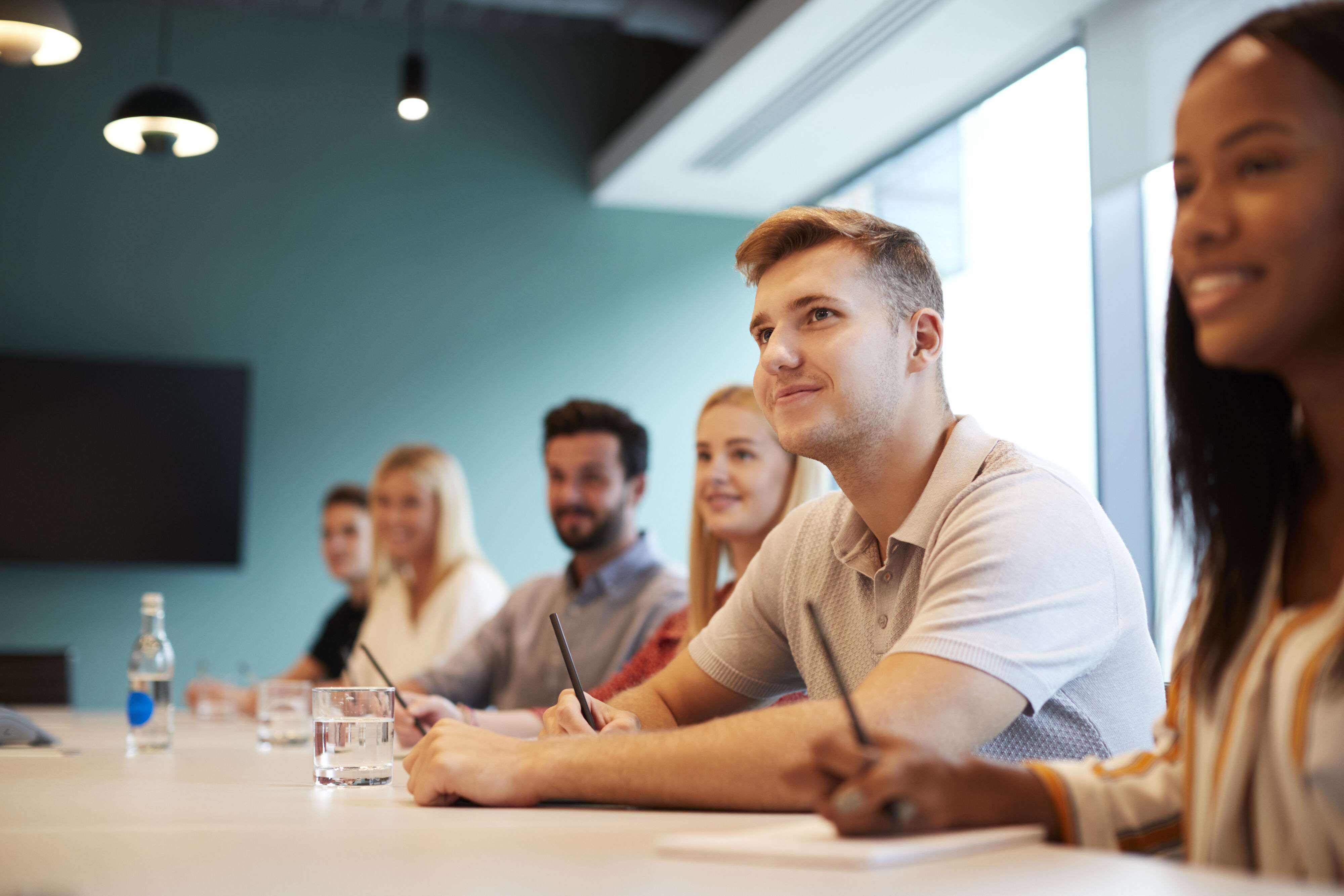 Young professionals in meeting room with note books