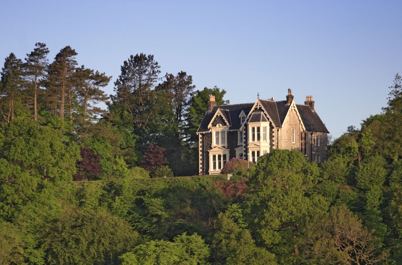 Large house on rural hill surrounded by trees