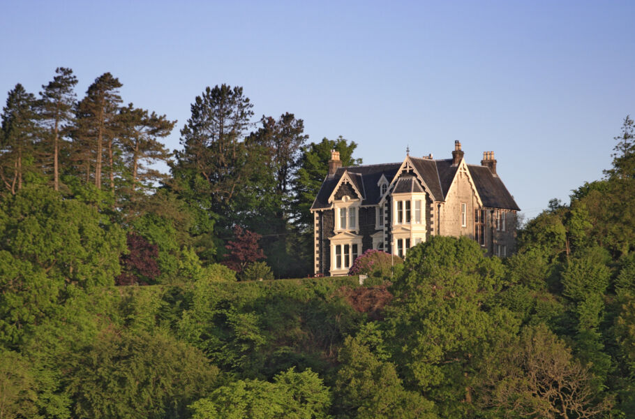 Large house on rural hill surrounded by trees