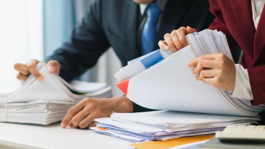 Two people running through paperwork