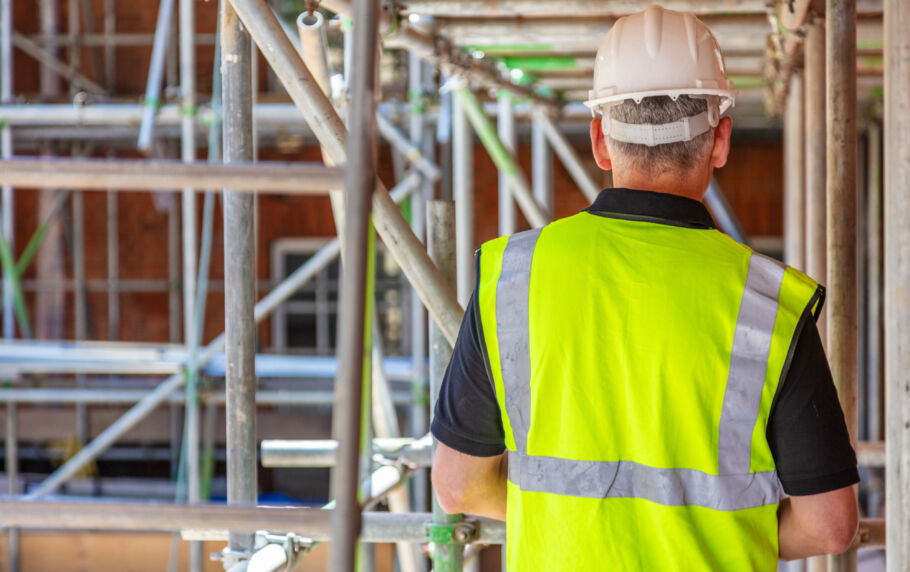Construction worker standing on scaffolding on construction site