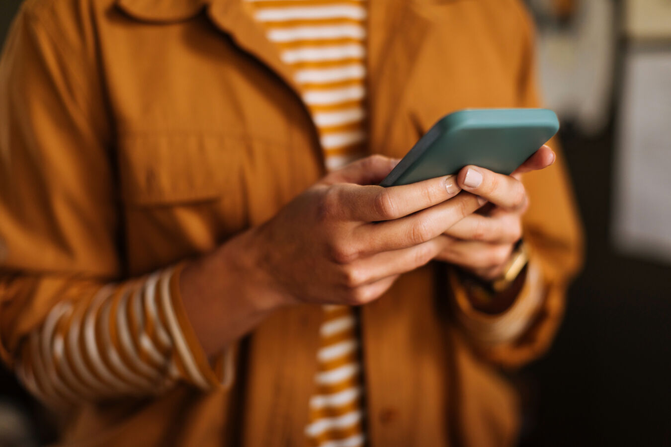 Woman wearing orange looking at phone