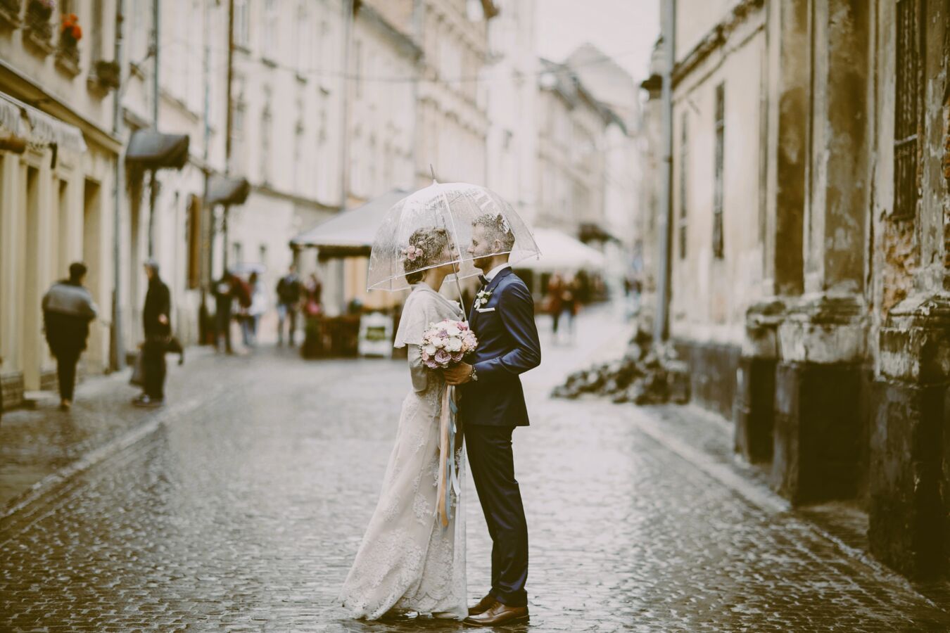 Couple under embrella in street on their wedding day - vintage