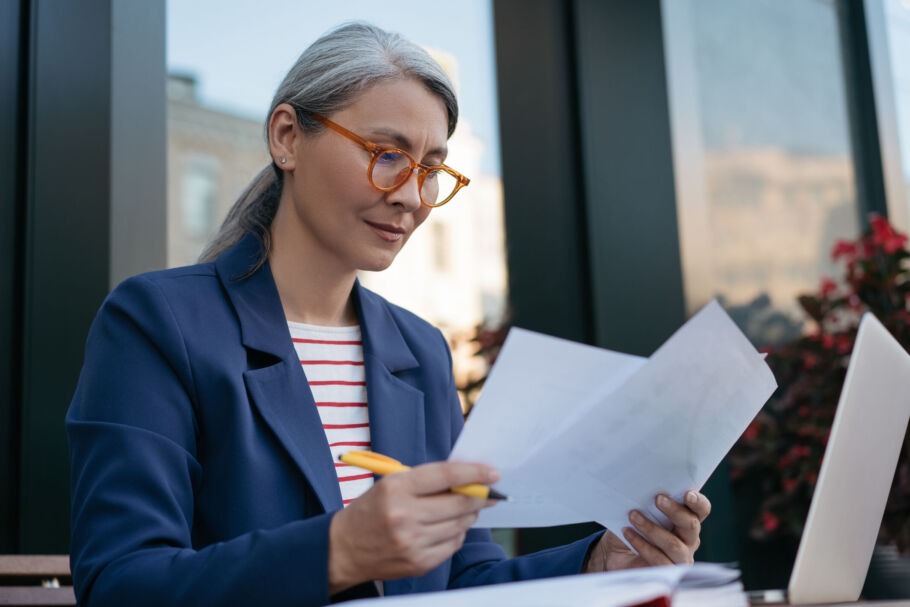 Woman reading documents with pen in her hand