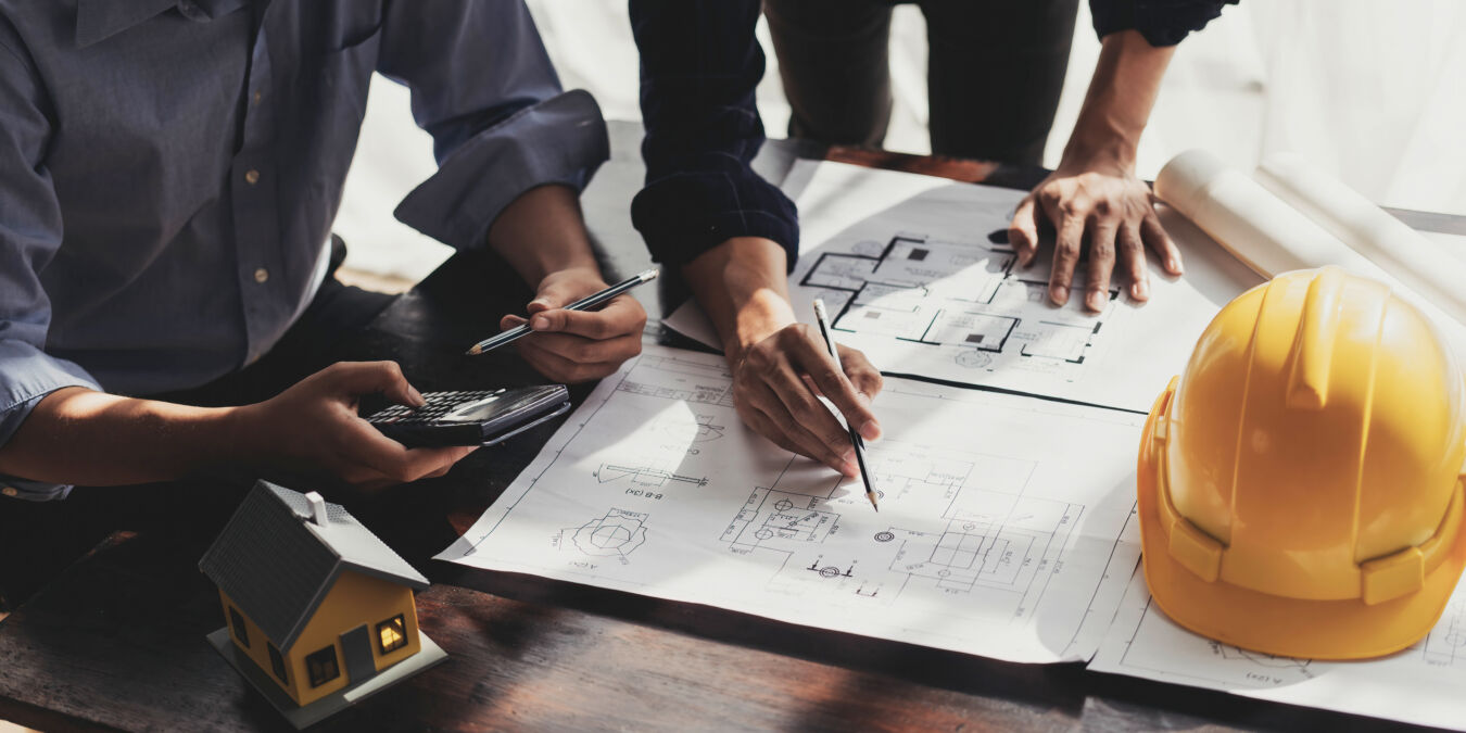 Builders and architects working on building construction plan