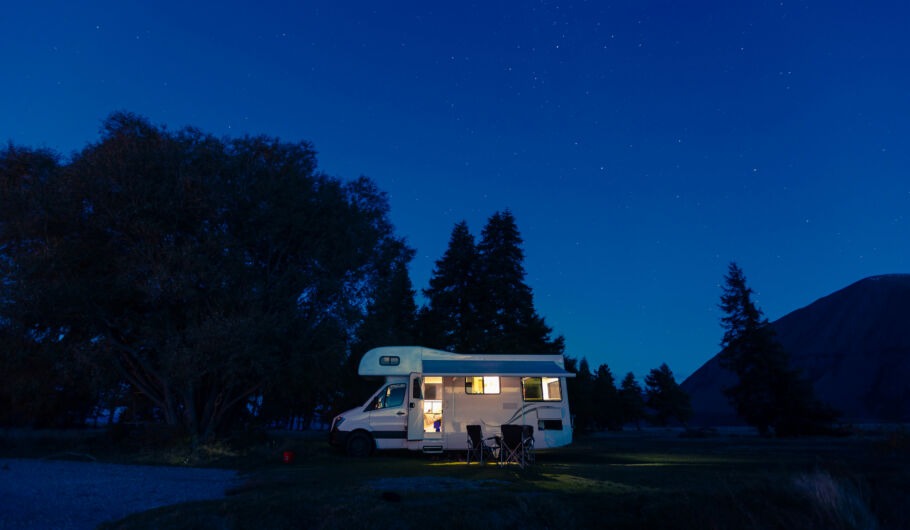 Caravan in dark field at night