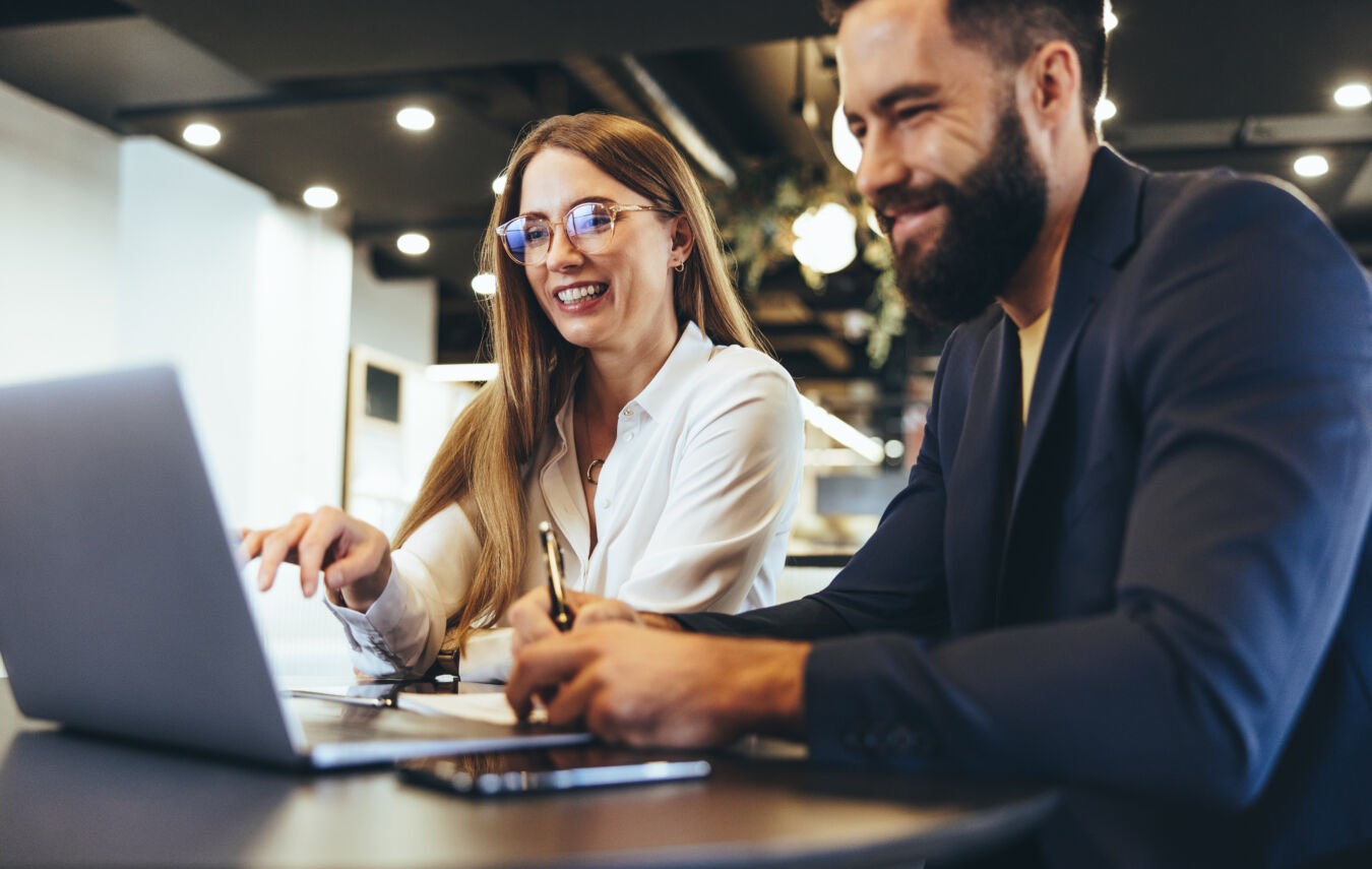 Two people working together at laptop