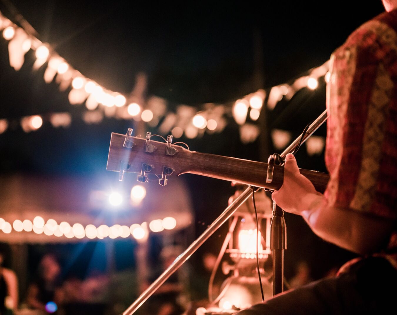 Musician playing guitar for crowd at venue