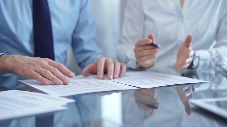 Two people in discussion across paperwork