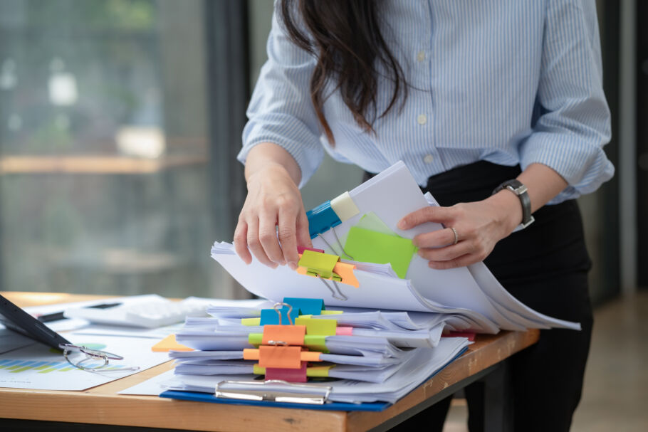 Woman flipping through stack of colour coded paperwork
