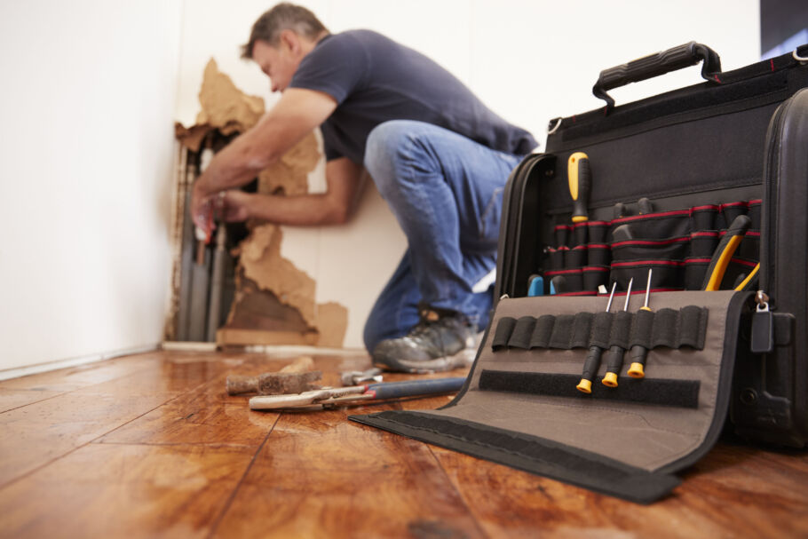 Tradesman repairing broken burst pipes