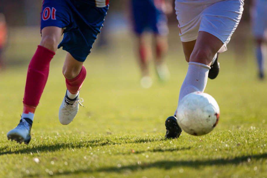 Two football players running for the ball