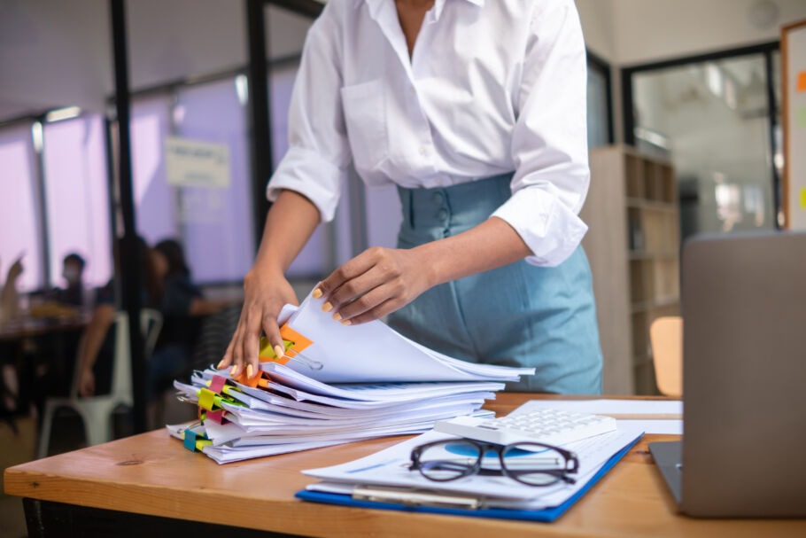 Woman flipping through paperwork at desk