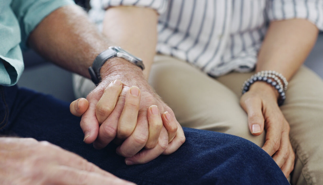 A couple holding hands, comforts each other