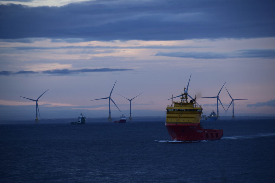Ship with offshore wind turbines behind it